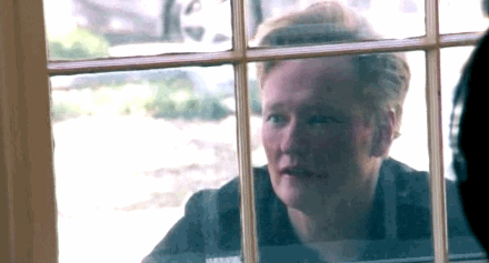 Conan O’Brien looking through a window gif